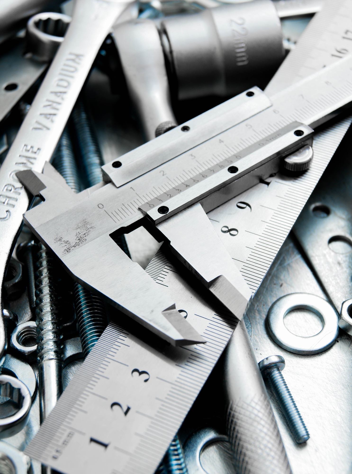 Caliper and tools on the scratched metal background.